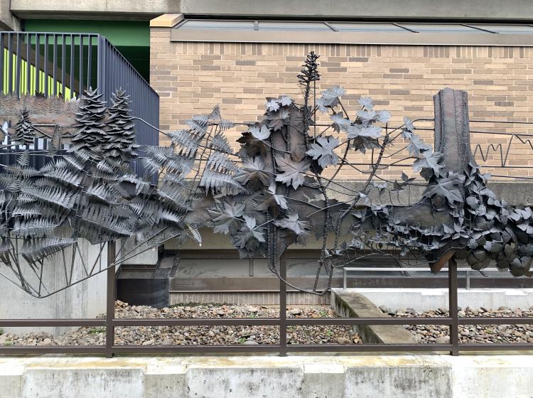 A section of the sculpture, depicting trees and leafy vegetation