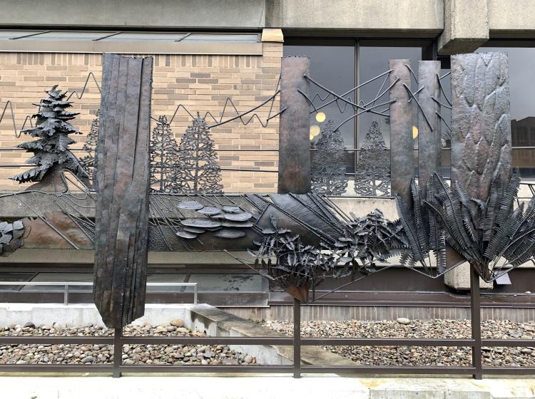 A section of the sculpture, depicting trees and the outline of mountains