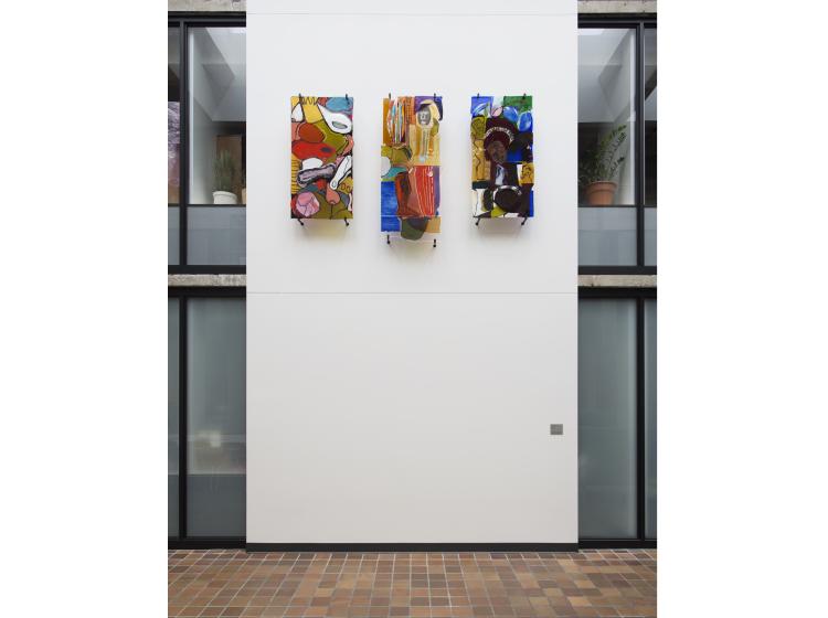 The three glass artworks are seen from slightly farther back. The floor can be seen