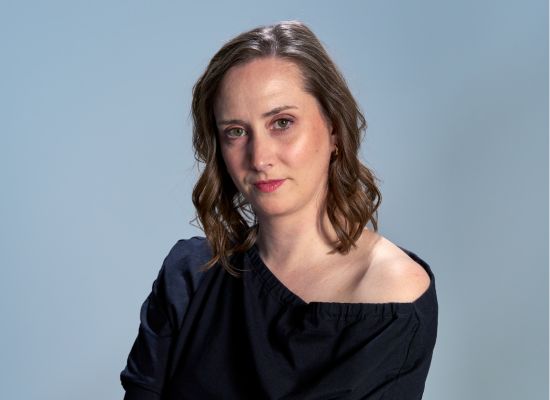 A woman in front of a blue background.