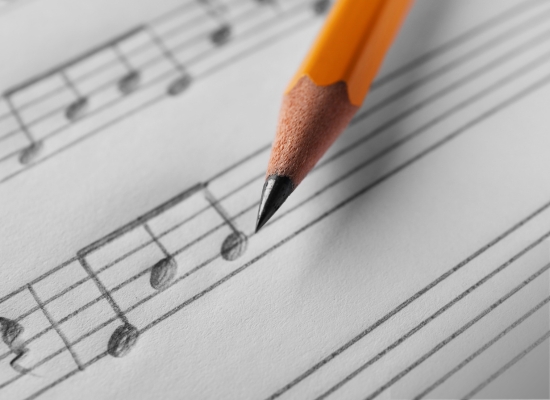 A pencil and handwritten sheet music.