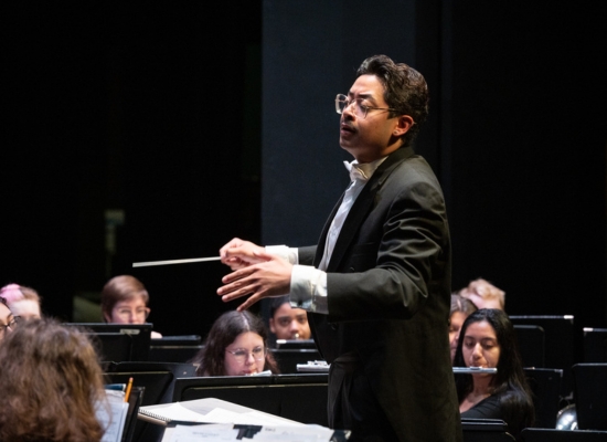 Photo of a graduate student conducting a wind ensemble