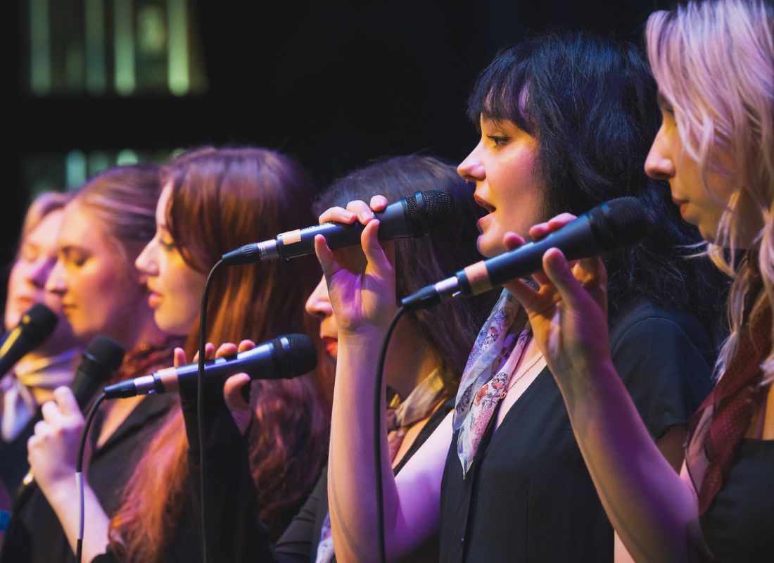 Photo of PSU Vocal Collective singing into microphones.