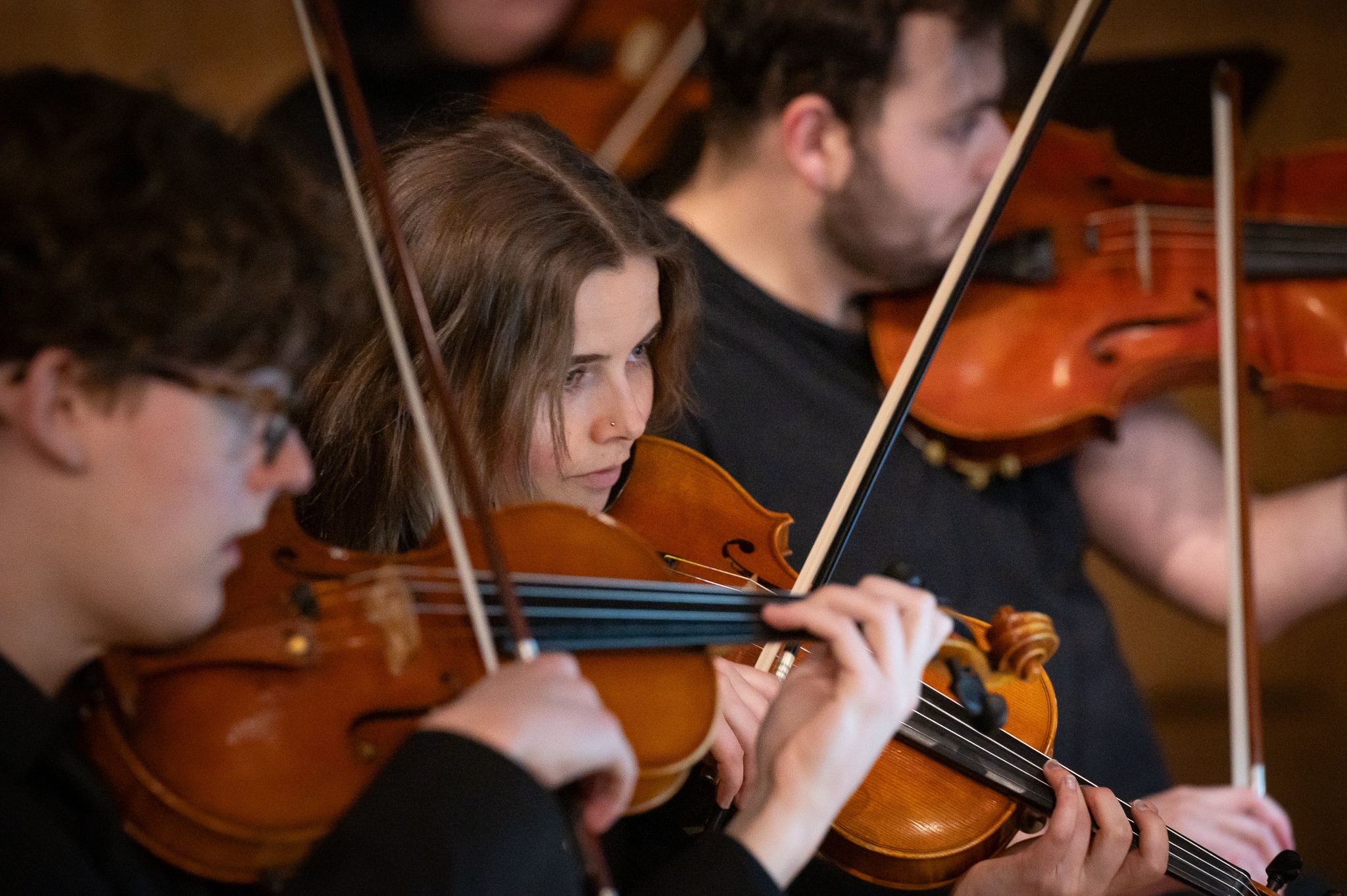 PSU Orchestra students playing violin in a concert.