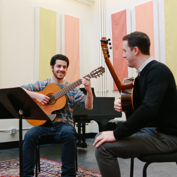 Guitar student and instructor in private lesson