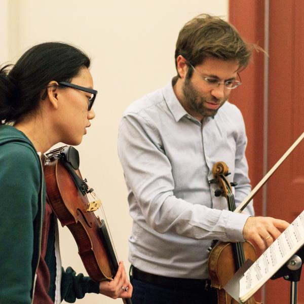 Violin student and instructor in private lesson