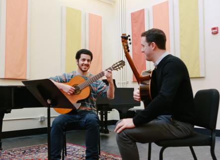 Guitar student and instructor in private lesson