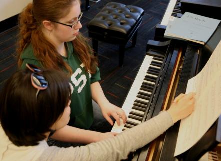 Piano student and teacher in private lesson