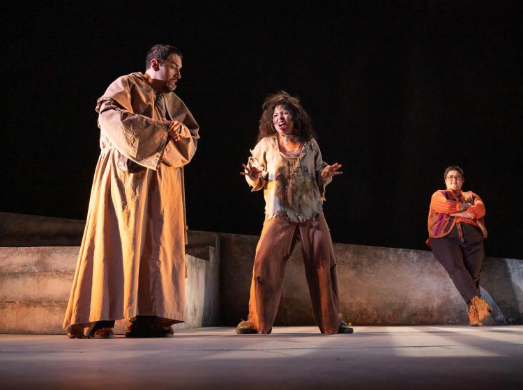 A friar speaking with a deranged looking prisoner, from PSU Theater's production of "Measure for Measure"