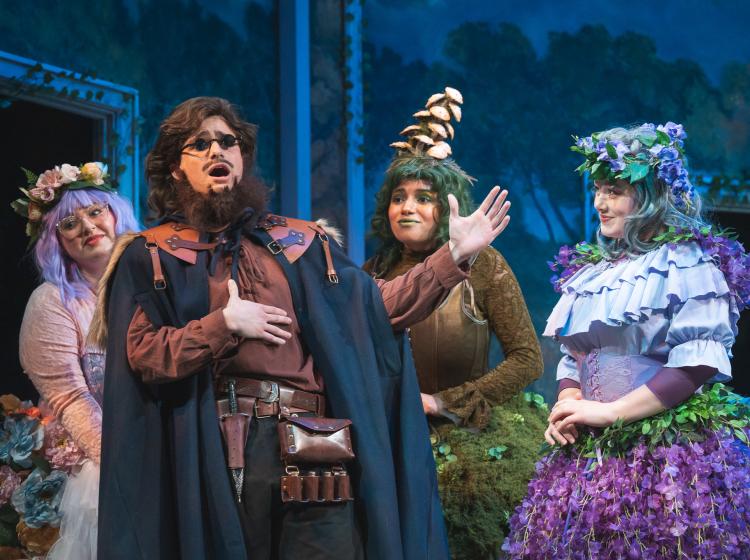 PSU Opera students dressed as forest fairies, and a man singing to them.