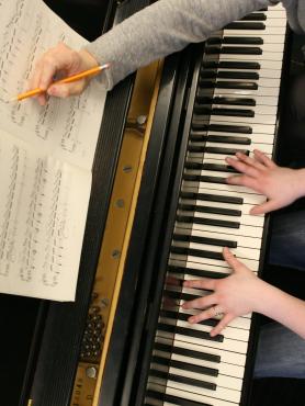 Instructor and student edit a score at the piano