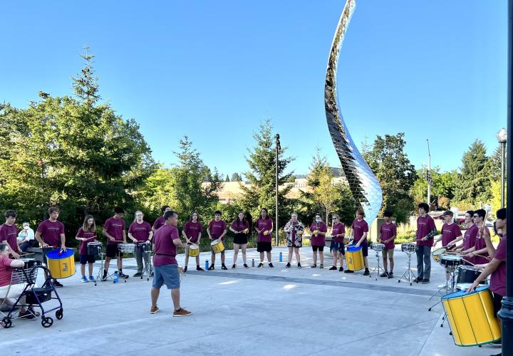 Students performing samba percussion outside.