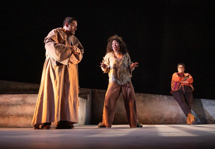 A friar speaking with a deranged looking prisoner, from PSU Theater's production of "Measure for Measure"