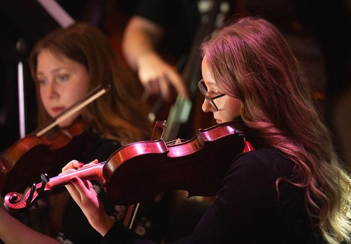 Student playing a strings instrument