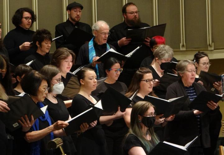 Photo of the PSU University Choir singing with music folders.