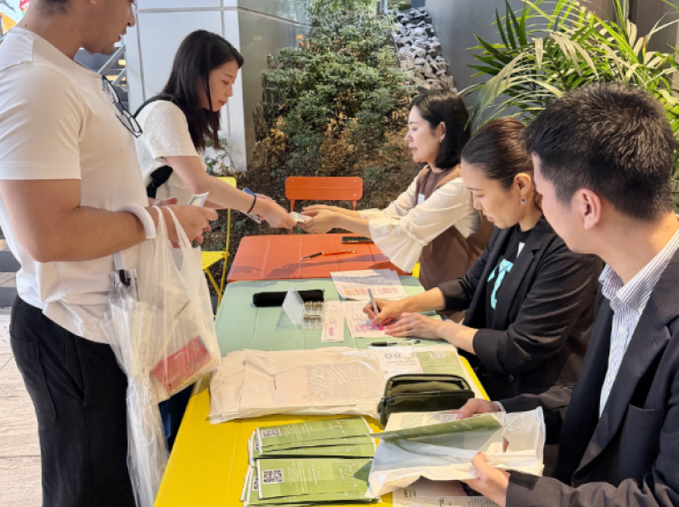 Student registering at sign in table of Tokyo Alumni Gathering