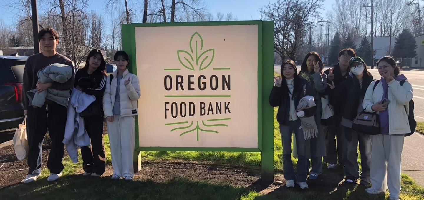 Students standing next to the Oregon Food Bank sign