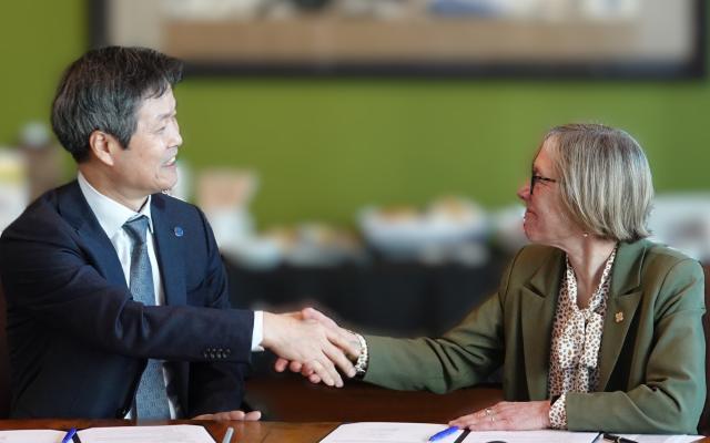 President Ann Cudd shaking hands with a delegate from Seoul