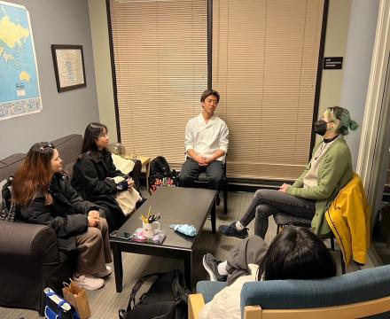 Students sitting around a table in conversation with one another
