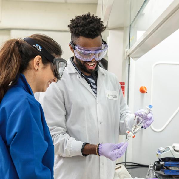 Students in lab with coats and safety goggles
