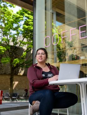 Student outside cafe with laptop