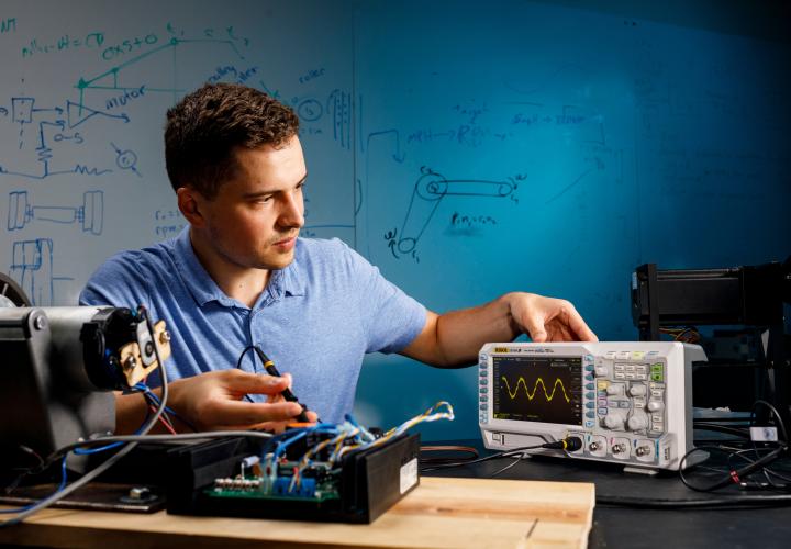 Student with electronics in lab