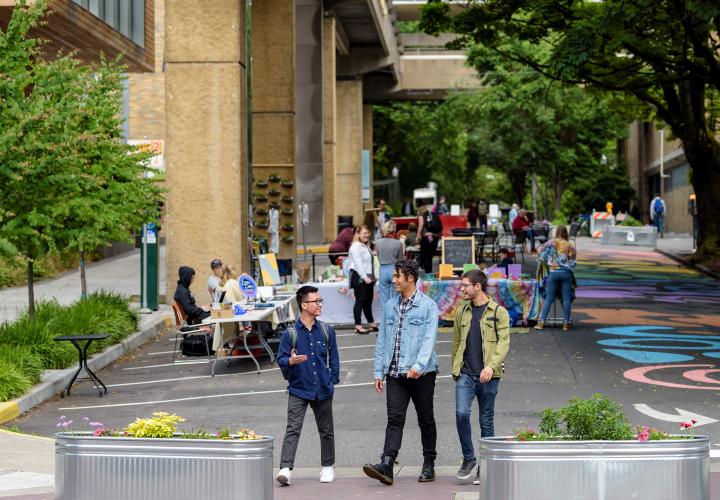 picture of montgomery plaza with three people in foreground and tables in background