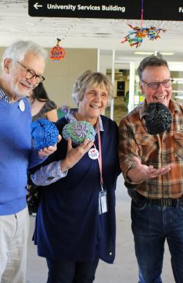 picture of three people with brain models