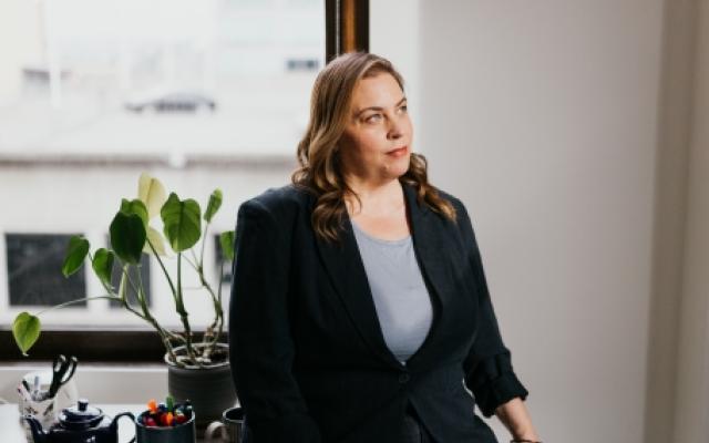 picture of Lizzy Caston in an office with a white backround