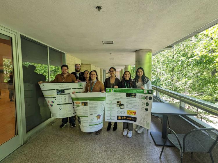Lab members holding up scientific posters