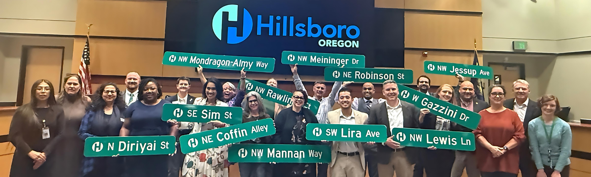 The 2025 Hillsboro Civic Leadership Academy cohort standing together in City Hall with street signs with their names on them.