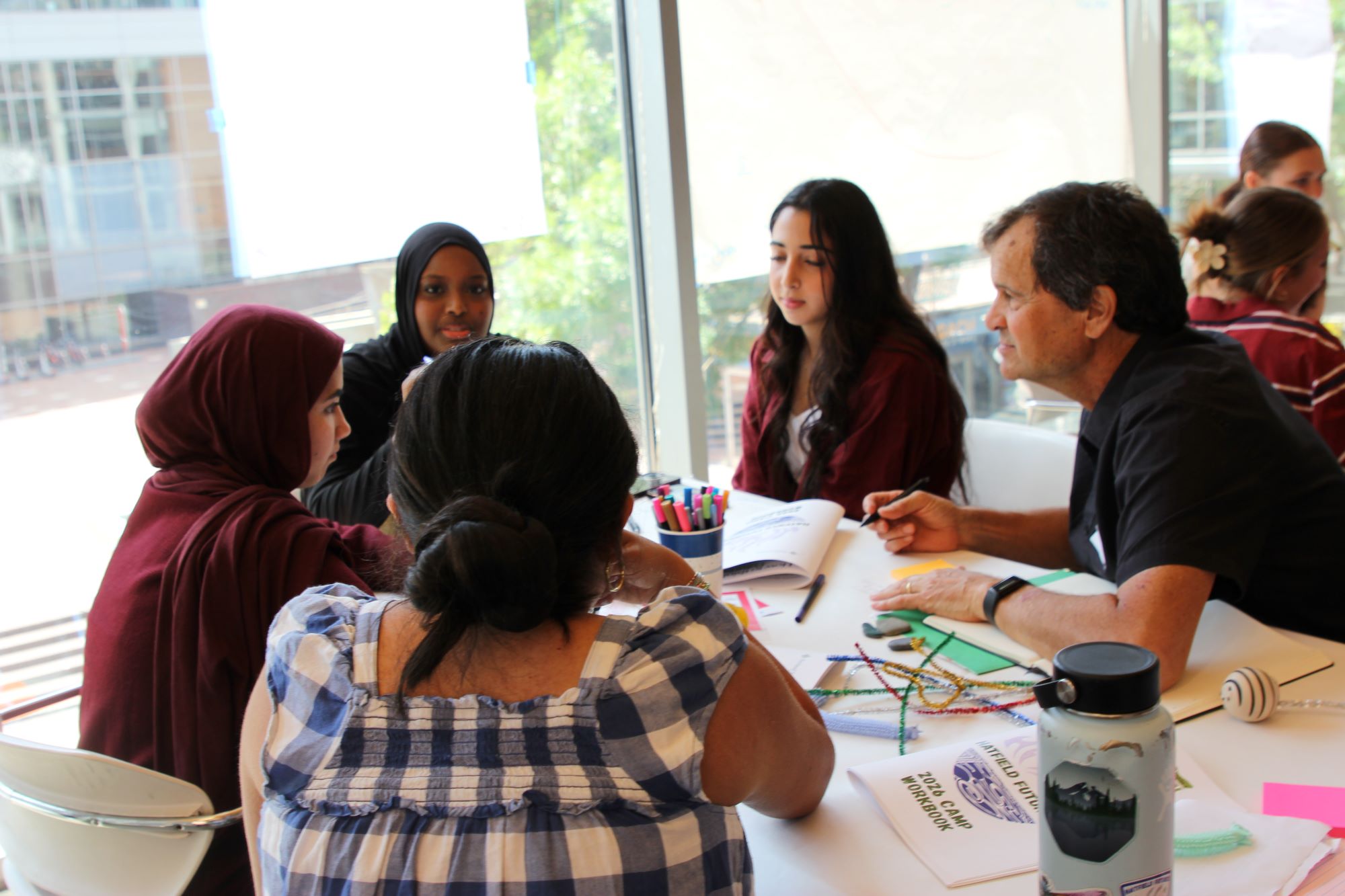 A group of Hatfield Futures students sitting around a table in conversation with their team guide