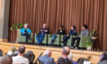 The panel of speakers for the OC 20th anniversary party sitting on the stage
