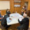 A group of people sitting around a table in Paisley, OR, reviewing a map together