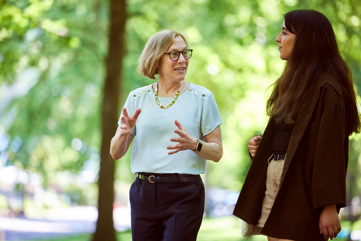 President Ann Cudd walking with student