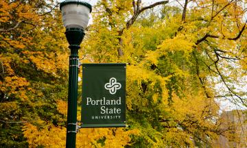 PSU flag against the fall foliage on the park blocks. 