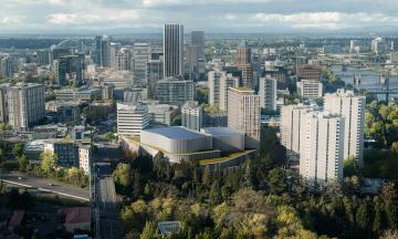 Arial view of PSU's proposed Portland Performing Arts + Culture Center with trees in the foreground and city buildings beyond.