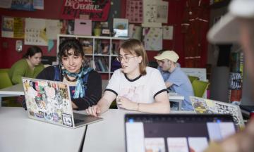 Students in a classroom with a laptop. 