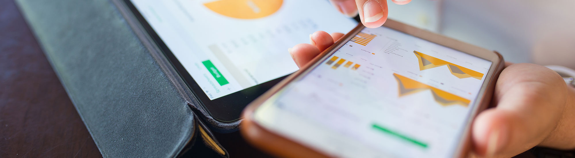 Woman with charts on a tablet and smartphone