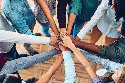 A group of people with their hands together in a circle