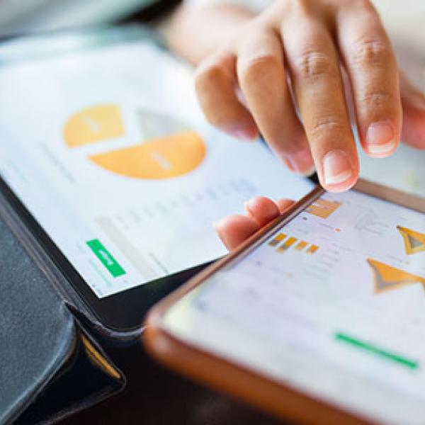 Businesswoman checking data in smartphone and tablet