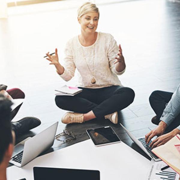 Woman leading a meeting sitting on the floor in a circle