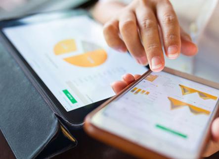 Businesswoman checking data in smartphone and tablet
