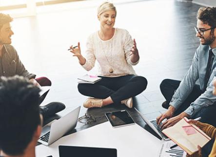 Woman leading a meeting sitting on the floor in a circle