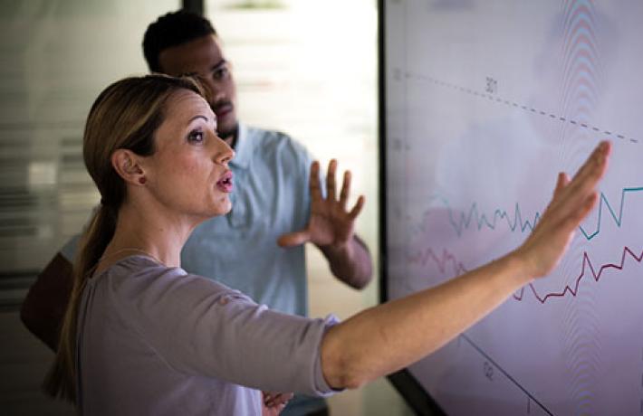 Woman at touch screen with charts