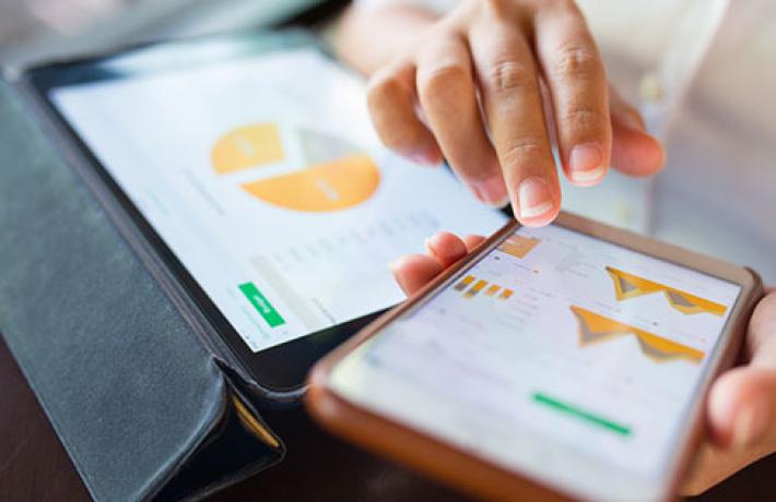 Businesswoman checking data in smartphone and tablet