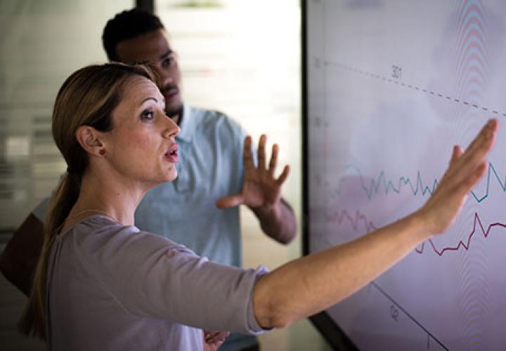 Woman at touch screen with charts