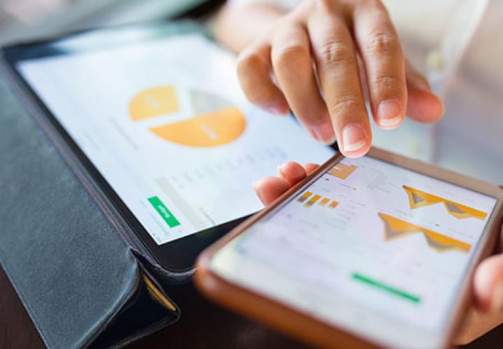 Businesswoman checking data in smartphone and tablet