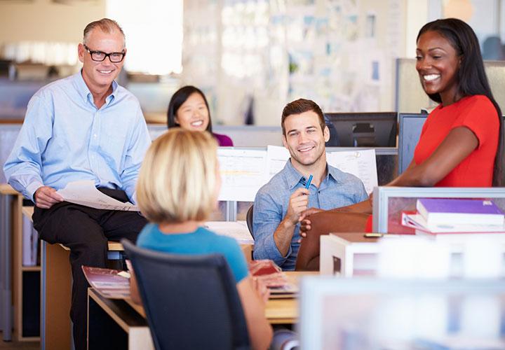 Happy colleagues having a meeting in an open plan office