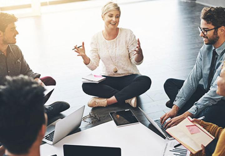 Woman leading a meeting sitting on the floor in a circle